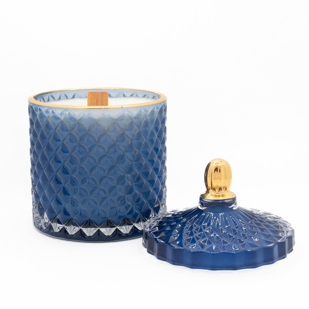 lid next to candle, blue and gold, gloss cut glass candle, wooden wick, bold and beautiful. 